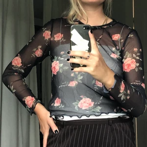 Blommig mesh-tröja - Svart/blommig meshtop. Snygga detaljer i kanter. Passar fint under en top eller över ett linne/bh. Säljer pga använder knappt (blommor är inte min grej) 🌸