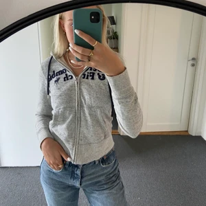 Zip hoodie - Gråmelerad hoodie med dragkedja från abercrombie and fitch. Storlek XS❣️
