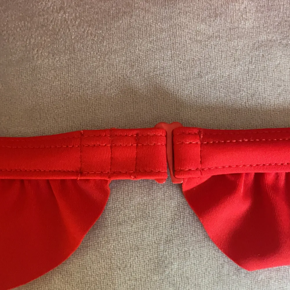 Röd bikinitopp med volanger. Den är endast testad och är i toppskick. Bikinin har justerbar knäppning i ryggen. Säljer pga att den är lite för stor för mig. Frakten är inte inräknad i priset!❤️. Toppar.