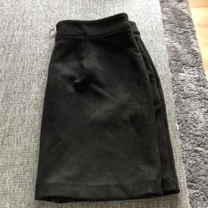 Svart mockakjol med guldiga dragkedja. - Svart mockakjol med guldiga dragkedja där bak. Fickor fram. Från Vero Moda. Storlek M. Katt finns i hemmet.