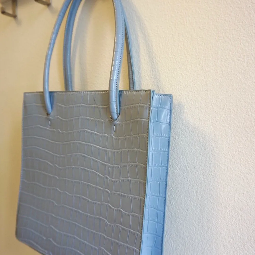 En ljusblå väska från min tidigare egna webbshopp. Höjd: 29 cm, bredd: 28 cm. . Väskor.