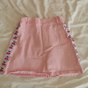 Supersöt kjol köpt från märket WC i Japan, rosa kjol med körsbär och lila detaljer på sidorna🎠🌸säljer då den inte längre passar, jättefint skick med resår i midjan. Storlek xs💕