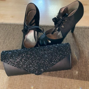 Klackskor och väska stl 38 - Skor i siden, använda 1 gång tillsammans med väskan på min student. I fint skick båda två.