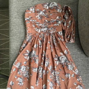 Blommig klänning Stockhlm - En bustier(korsett) festklänning med blommigt tryck i storlek 34(XS). I bra skick. Köptes på MQ. Vill ni köpa två plagg, då skickar jag fraktfritt 