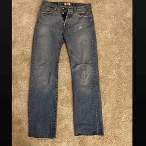 Levis Jeans 501 - Vintage Levis jeans i modell 501💙 De är i herrmodell i storlek 29. De är stora på mig som har 34 så skulle passa någon med storlek 36-40 beroende på hur man vill att de ska sitta💫 De är klippta så längden är ungefär 30, jag är 160. De har oxå ett hål på ena knät💙 kan postas så frakt tillkommer🌟 Skriv för mer bilder!!