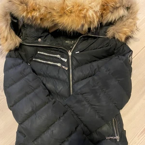 Hollis jacka med äkta päls i storlek xs  - Hollis jacka med äkta päls. Jackan är svart. Köpes för 6000 säljer den för 3000. Jackan är i fint skick. Jackan är perfekt för vintern. Jackan sitter fint på kroppen. 