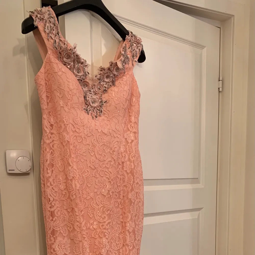 En helt ny klänning, helt oanvänd. Perfekt till evenemang av olika slag. I rosa spetts med silvriga detaljer.. Klänningar.