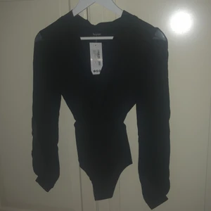 Wrap Bodysuit  - Helt nyskick, aldrig använd. Bilden tycker jag själv är väldigt missvisande men tror inte plagget finns kvar på Boohoo’s hemsida då jag inte hittar den och den är så liten för mig att jag inte får på mig den. Är i storlek S men jag som ofta bär det och är 173cm passar den inte så skulle rekomendera för dig som kanske är kortare eller bär XS. Täcker bra över kroppen men armarna är ett mer genomskinligt material och har en öppning vilket är väldigt snyggt.