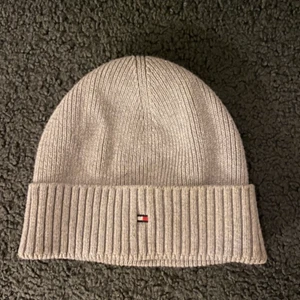Grå mössa - Säljer en Tommy Hilfiger mössa i storlek onesize som köptes för 300-400kr säljer för 100kr! Använd fåtal gånger och är i bra skick!