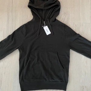 Filippa K M. Arthur hoodie strlk XS - Filippa K M. Arthur knitted hoodie i storlek XS. Stickad, mörkgrön/mörkbrun hoodie i fin kvalitet med snören. Köpt för 1700kr och aldrig använd (etiketten är fortfarande kvar). Sitter som en vanlig XS. Skick 10/10 då den aldrig är använd och etiketten sitter kvar. Tröjan är en herrtröja men funkar lika bra för tjejer.