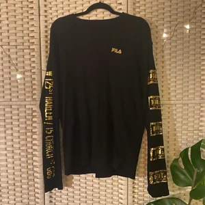 Tröja FILA - Långärmad tröja med guldtryck på ärmarna från Fila i fint skick storlek S, sitter oversized så passar även M