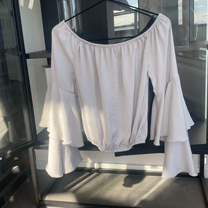 Blus i lyxigt material med volangärmar - SÅ FIN blus i lyxigt material med volangärmar. Går att ha som vanligt eller off shoulder då den har gummiband både upp- och nertill. 