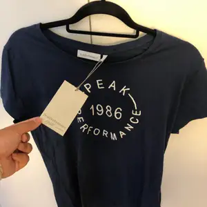 Peak Performance Marinblå T-shirt helt ny, prislappen är fortfarande kvar! Köpt från Intersport. Storlek L men lite tajt så mer som ett M. Kan mötas up i Stockholm eller frakta men köparen står för frakten✨