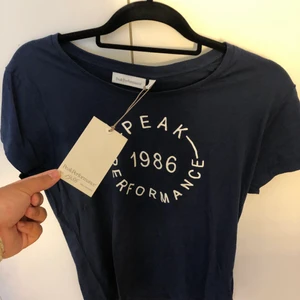 Peak Performance Marinblå  - Peak Performance Marinblå T-shirt helt ny, prislappen är fortfarande kvar! Köpt från Intersport. Storlek L men lite tajt så mer som ett M. Kan mötas up i Stockholm eller frakta men köparen står för frakten✨