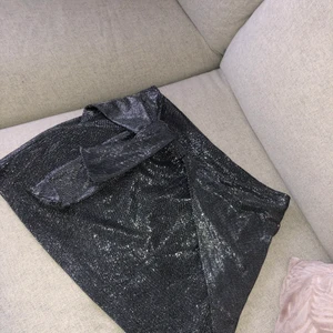Glittrig kjol stl S - Kjol från bikbok, passar till fest eller nyår! Har en dragkedja och kan knytas framtill för anpassa storlek lite mer. Skulle säga den passar för även någon som är stl M. 