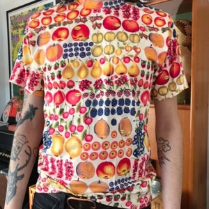 Rolig 90s tisha!  - En fruktlåda! Fin i skicket, 90-tal. Tror det är nån bomullsblanding men är ändå mjuk och skön. Byst: 48 Längd: 67 