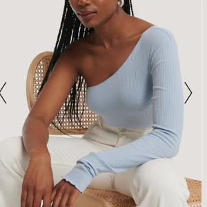 One shoulder tröja - Säljer denna one shoulder topp från NA-KD som köptes förra våren. Den är bara använd 1 gång, därför som i nyskick!! 💙💙 