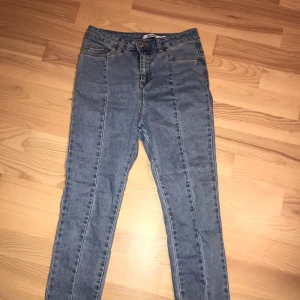 Jeans från Nakd - Supersnygga jeans från Nakd. Har en söm i mitten av benen och en slit längst ner. Dessa jeans är slutsålda för länge sen.
