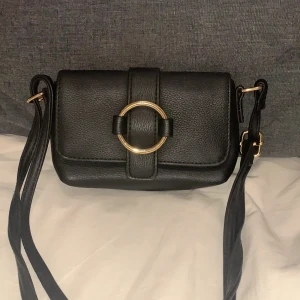 Liten väska HM - Väska köpt på HM i somras. Använd i skolan fåtal gånger och är perfekt som en mindre väska att förvara mobil, plånbok och nycklar i💕💕 100kr + frakt
