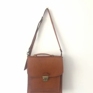 Skinnväska / Portfölj i äkta läder  - Underbar väska/portfölj i äkta läder som bara blir finare för varje år! 🌸  Mått: Bredd 30 x Djup 11 x Höjd 34cm   Rymmer de flesta datorer och har bra mindre fack. 🌸  Kommer från ett djur- och rökfritt hem.   Ser helst att köparen kan mötas upp i centrala Stockholm men kan även skickas och då tillkommer fraktkostnad för köparen. 🌸 