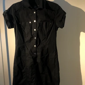 Vintage Klänning Peak Performance  - Jag säljer min vintage Peak Performance skjortklänning eftersom att den är för liten för mig!   Den är mörkblå med snygg form och sitter lite löst, den är storlek M som är motsvarande till storlek 36. Materialet är väldigt luftigt så den är perfekt att ha på sig under en varm sommardag!  Den är i superfint skick o har inte några synliga skador eller fläckar på sig!  Köparen står för frakt och om du har några andra frågor så hör bara av dig! 😊