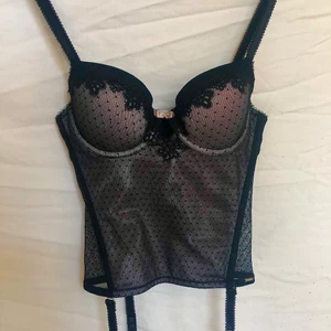 korsett - Underbar vintage korsett med rosa bas och svart spets! Gott defejtfritt skick. Har ej några bilder på då den är för liten på mig som bär M. Uppskattas passa Xs A-B kupa bäst