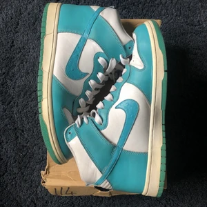 Nike dunk high mineral blue  - Säljer dessa Nike dunk High mineral blue från “ostrich pack” 2011 storlek 44.   De är i väldigt bra skick och de billigaste paret jag hittar ligger på ca 2000kr använda.   Det är originalboxen men den är ganska trasig.   Skriv om du vill ha fler bilder eller har några frågor. Kan fraktas eller mötas upp i Stockholm:)