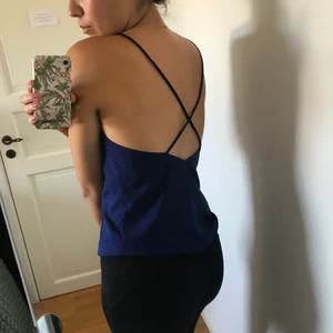 Blått linne från Ivyrevel, öppen rygg - Jättefint marinblått linne från ivyrevel med öppen rygg och flätade band. Tyvärr för stor över bysten på mig, är storlek S men kan även passa en M. Kan mötas upp i Stockholm eller skicka med litet postkuvert. 