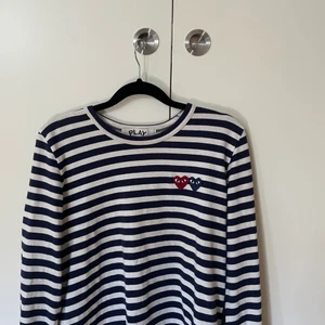 Comme des garcons tröja  - Trendig Comme des garcons (play) tröja. Köp på NK i Göteborg för 1400kr men säljer pga att jag inte får användning för den. Använd 2-3 gånger! Syns dåligt på bilden men ränderna är i mörkblå färg. Storlek L men passar XS-L beroende på hur man vill att den ska sitta. 