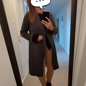 Trenchcoat (tunn höst/vår) i mörkgrön färg - Snygg trenchcoat i tunnare modell. Knytband och klassisk modell  