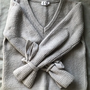 Supersöt stickad tröja!  - Stickad tröja från Linn Ahlborg x NAKD! Jättefin V-ringning och band som man knyter rosetter med runt handlederna🤍🤍 ganska stor i storleken, passar mig som vanligtvis har S/M