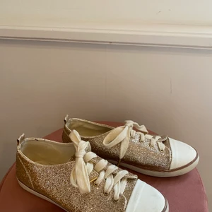 Glittriga sneakers storlek 36 - Glittriga sneakers i guld, sparsamt använda. Storlek 36 