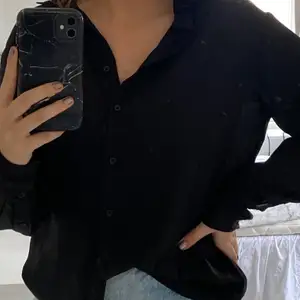 Jättefin svart skjorta i silkeslikt material!😍 den är lite oversized i modellen, men passar de flesta beroende på hur man vill att den ska sitta!💕 Köpt för ca 250kr! den är välanvänd, men i bra skick! Köparen står för ev fraktkostnader!💕