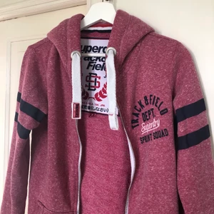 Superdry Zip-up hoodie - Fin superdry Zip-up hoodie, storlek XS men skulle säga att den även passar S. Bra kvalité och rejäl dragkedja. Syns knappt att den är använd! Fin hallonröd färg 🌺🌺 Köptes för 799, priset är diskuterbart vid snabb affär!