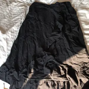 En svart kjol med volanger på från Lindex i storlek 146-152