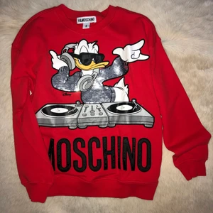 H&M x Moschino - Disney Donald Duck Sweater - Eftertraktad tröja ifrån H&M x Moschino i storlek S modellen Disney Donald Duck i röd färg. Tröjan är i perfekt skick (aldrig andvänd) och är i jätteskönt material. Jag trodde jag skulle få andvändning av den och nu har den hängt i garderoben allt för länge och förtjänar en ny ägare 🤍