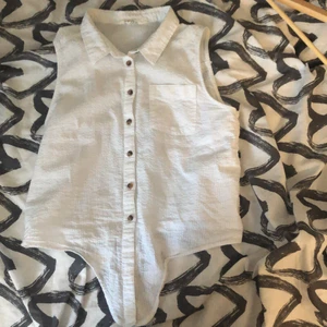 H&M blus - Vit lite ribbad knytblus med bruna knappar.