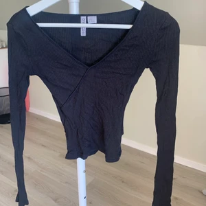 Svart tight tröja - En svart supersöt tröja som är passar perfekt till sommaren. Den ser ut som den gör på bilden för den är tight. Formar kroppen perfekt! Den är lite kortare och kan möjligtvis kallas croptop