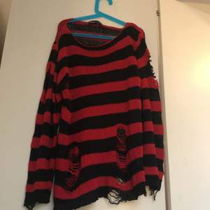 En röd/svart striped tröja med hål i (köpt så) 🌳