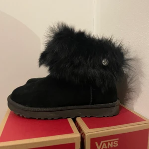 Ugg storlek 37 - Svarta mocka uggs med svart fakepäls runt om , använda ett fåtal gånger, superfint skick! Nypris 2000kr