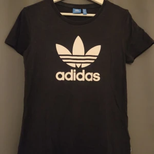 Adidas logo t-shirt - Svart t-shirt något insvängd i midjan. Kommer inte längre till användning