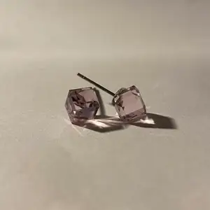 silverörhängen i form en rosa kub kristall med gulddetaljer.