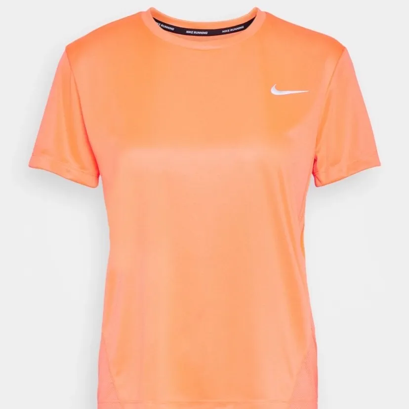 Neon orange träningströja från Nike. Obs bild nr 2 är den som säljs. Är i storlek xs och är figursydd. Ni kan buda på denna! . T-shirts.