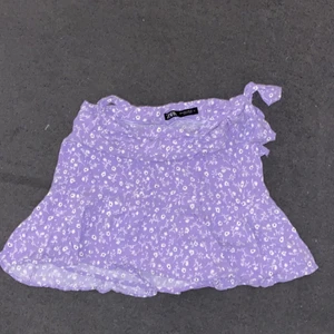 Zara blommig kjol - Säljer denna jätte fina lila kjol från zara som var väldigt populär förra sommaren💜 Den är strl M men råkade krympa den i tvätten så oklart vilken strl den är nu men den passar frf mig i midjan men har blivit lite för kort💗💜Den har undershorts! Endast använd 1 gng förra sommaren🥰 