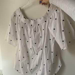Vit off shoulder topp med svarta prickar i ett ”skjortmaterial”, använd ca 3 gånger så fint skick💖 passar S och M