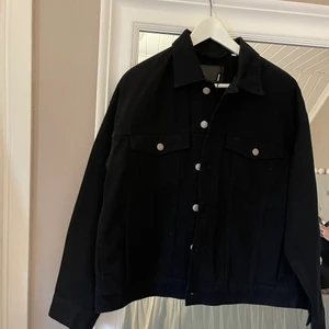 Svart jeansjacka - En snygg helt oanvänd svart jeansjacka från Weekday. I storlek S men är lite oversized.