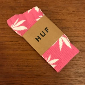 HUF strumpor  - Rosa med vita löv från HUF, flera färgkombinationer finns. Storleken är en onesize, 39-42 ca, jag har 43 och dom passar perfekt. Har du 35-37 så blir dom bara lite högre upp på benet. 