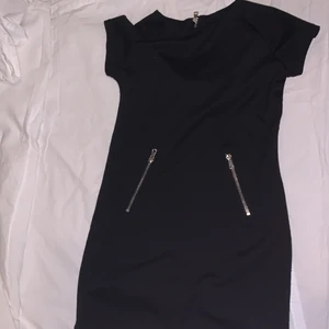 Cool klänning med dragkedjor där fram. - Svart klänning med stretchigt tyg. Aldrig använd