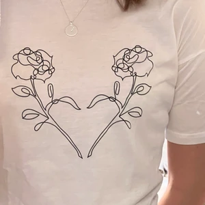 Vit t-shirt med blomdetalj strl xs - T-shirt i strl xs           Blommotiv Använt ett fåtal gånger men är i bra skick Säljs då den är för liten för mig 