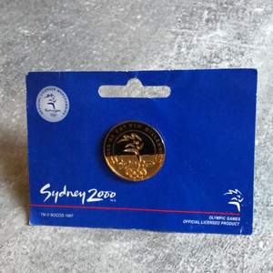 Oöppnad pin från OS i Sydney år 2000. Väldigt ovanligt att finna dessa tillsammans med sin originalförpackning. Pris 100kr.